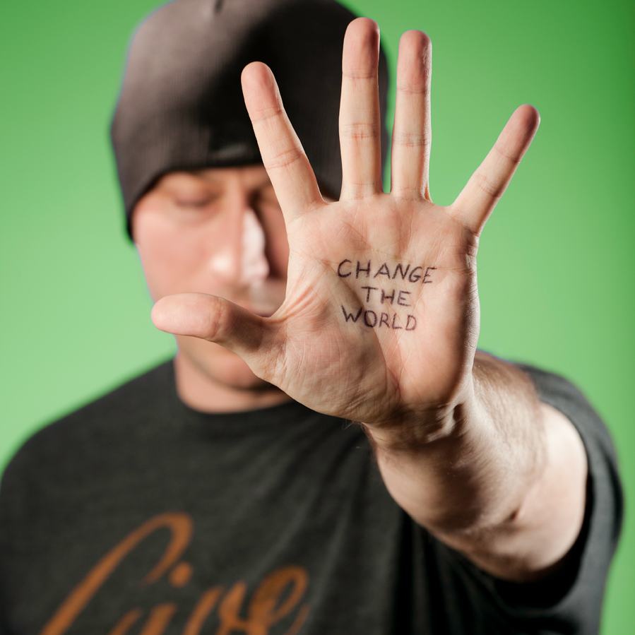 Nate St. Pierre holding up a hand reading "Change the World"