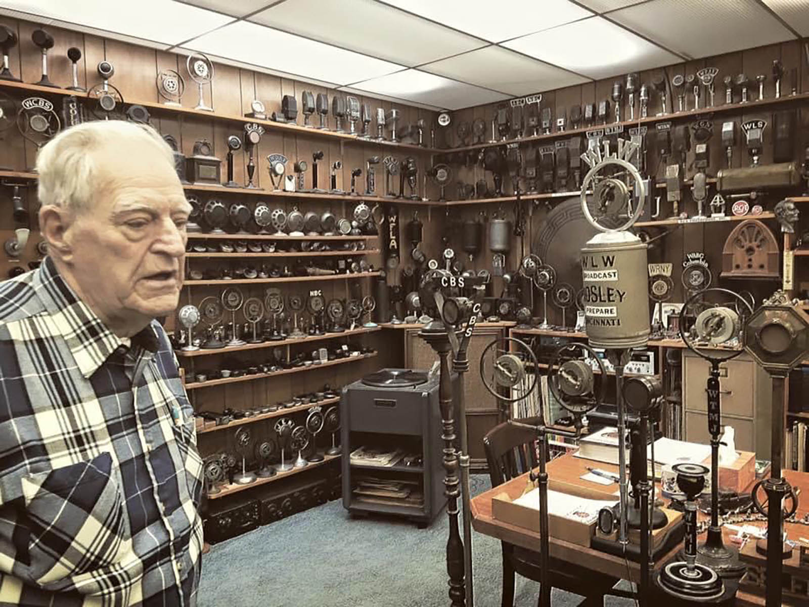 Bob Paquette standing in his microphone museum